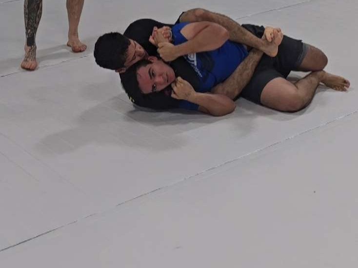 Rolling on the mat during a jiu-jitsu session.