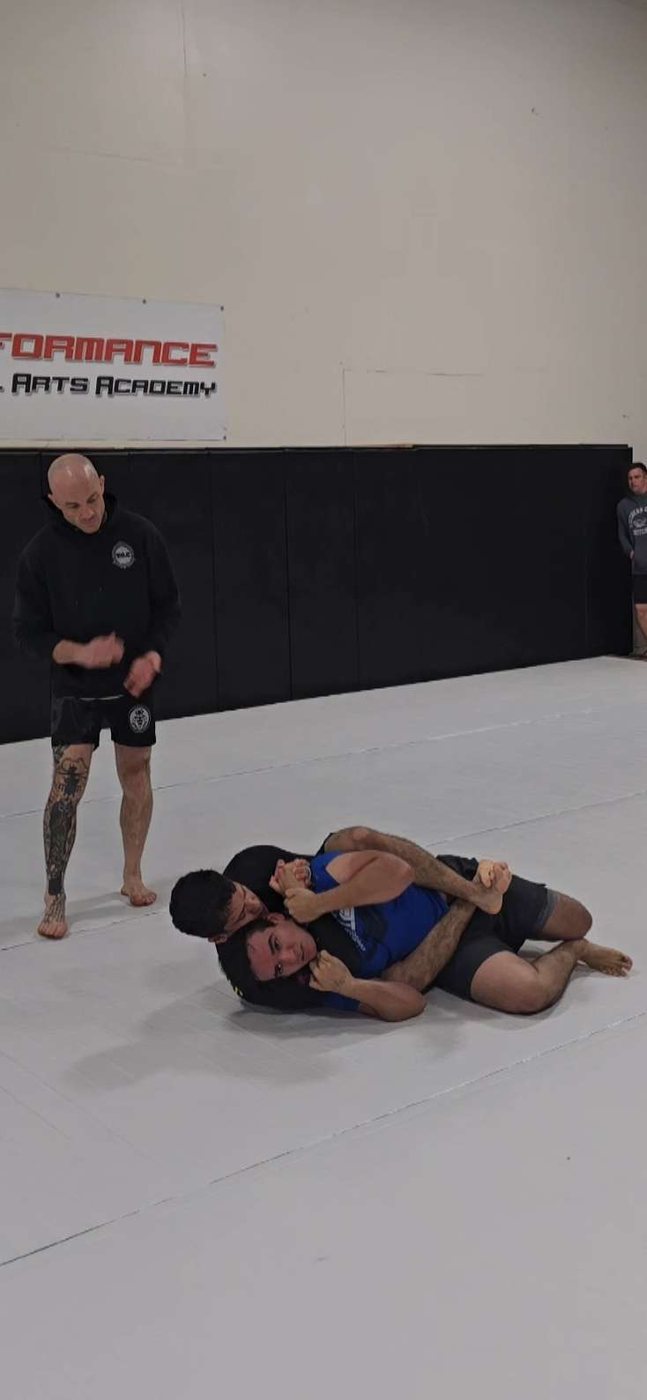 Rolling on the mat during a jiu-jitsu session.