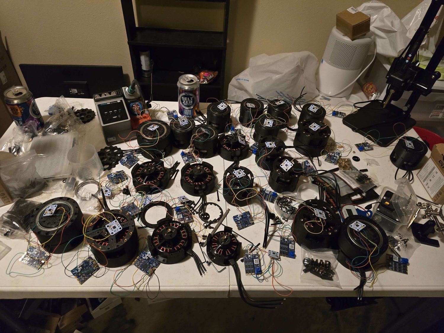 All 22 actuators with their motor controllers soldered and laid out on the bench.