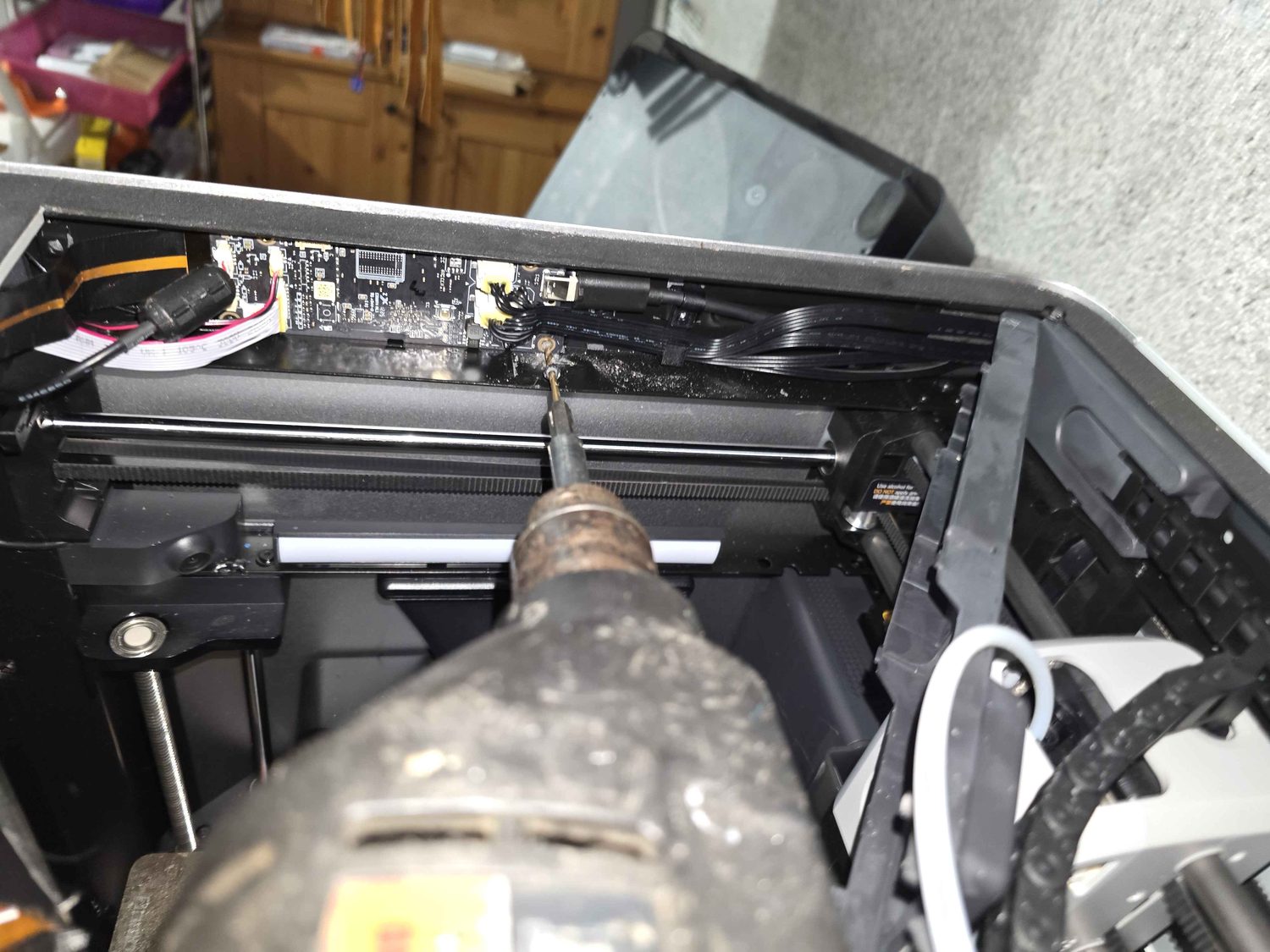 The 3D printer opened up with its screen and ribbon cable removed for repair.
