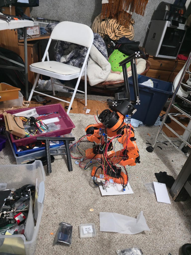 Humanoid lower body standing on carpet, orange printed legs on a black extrusion torso frame.