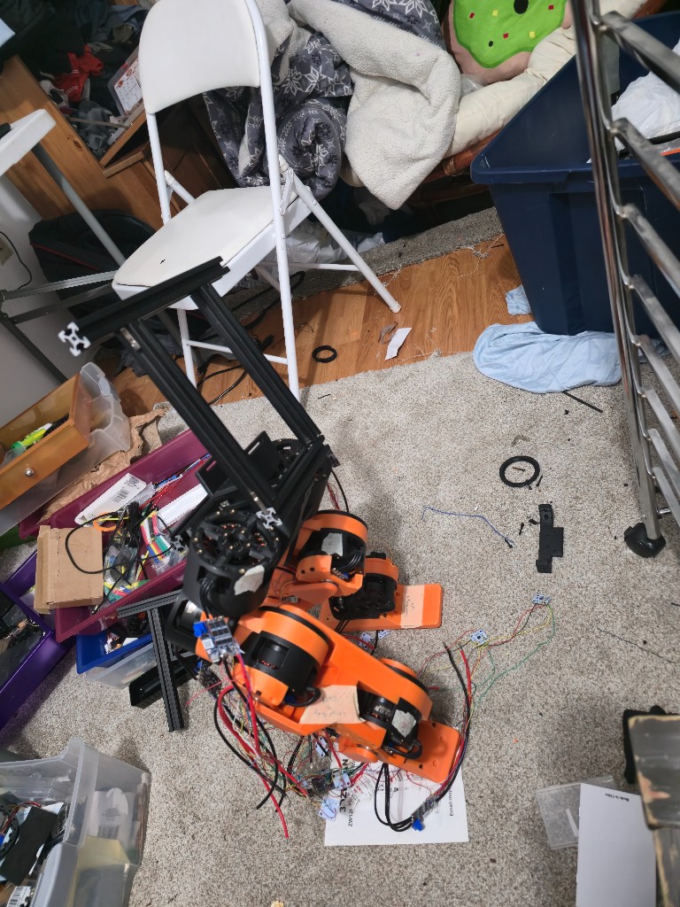 Second view of the standing humanoid legs with a 3D printer in the background.