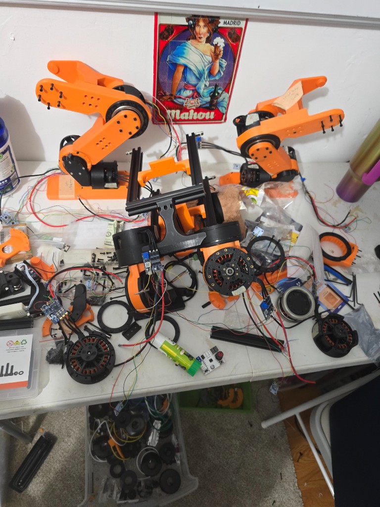 Upper-body parts back on the bench — arms, extrusions, and actuators while the frame is apart.